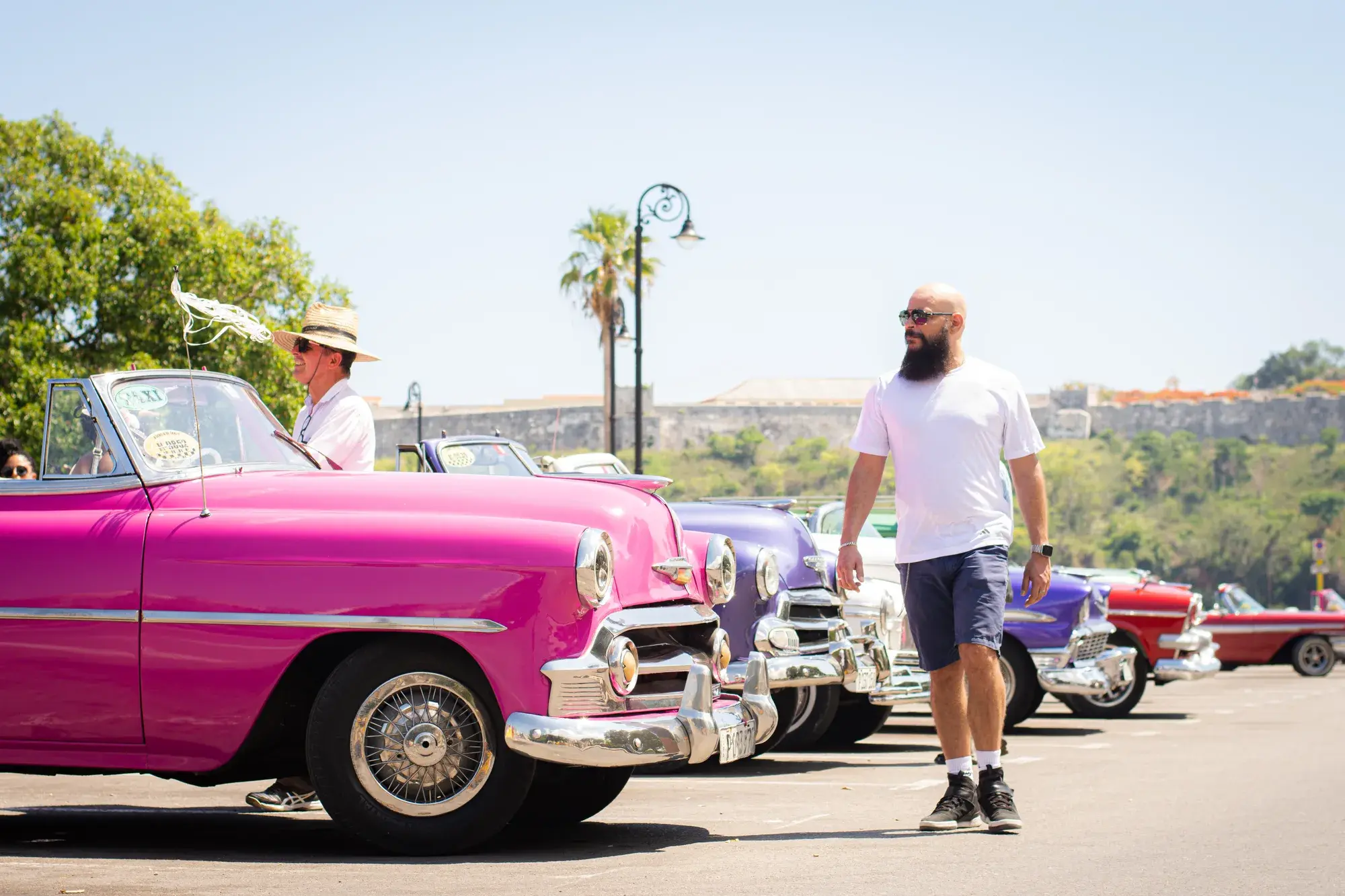 Caminando junto a coches clásicos en La Habana